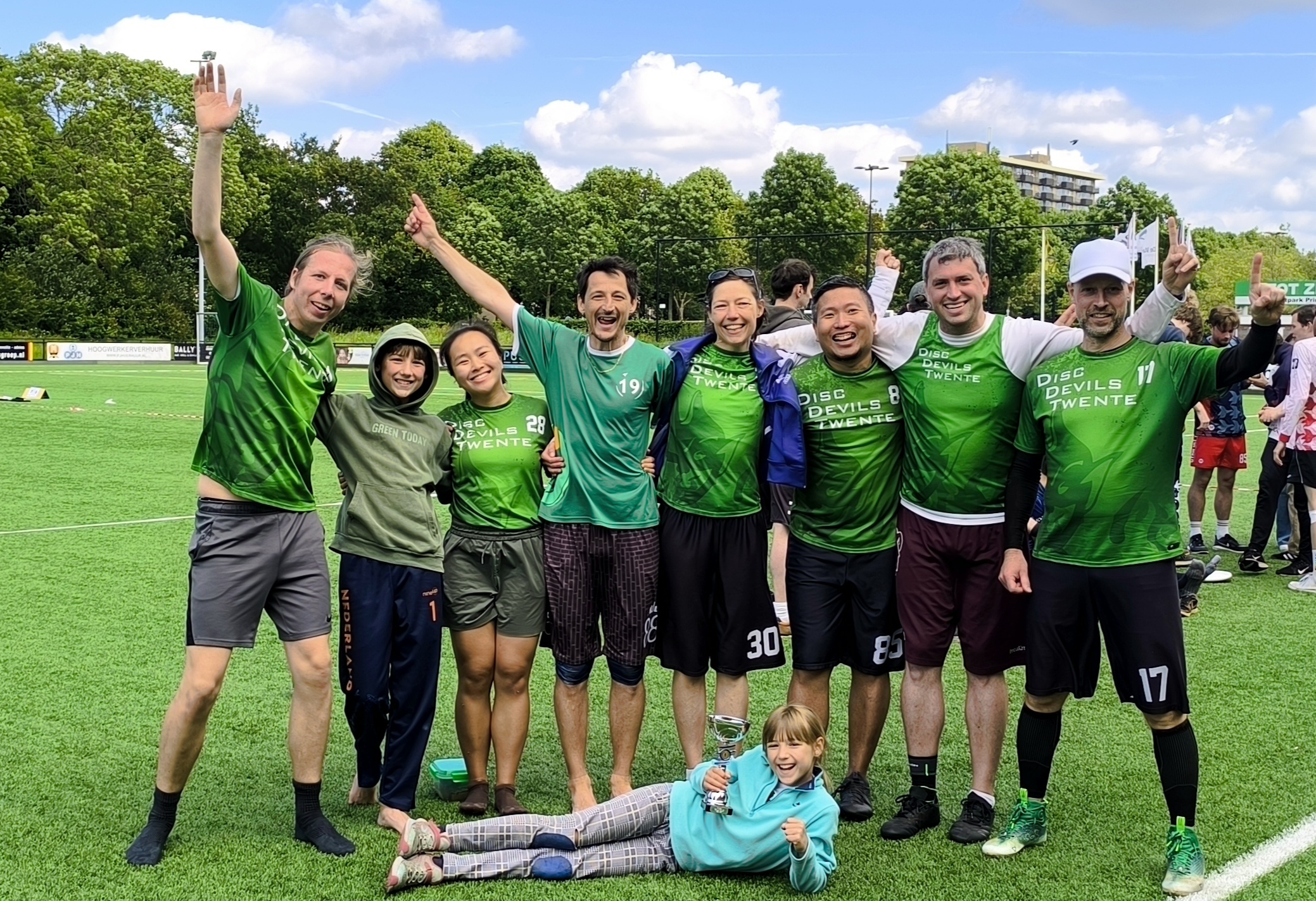 A picture of Ultimate frisbee players posing with a trophy after winning the Netherlands outdoor competition.